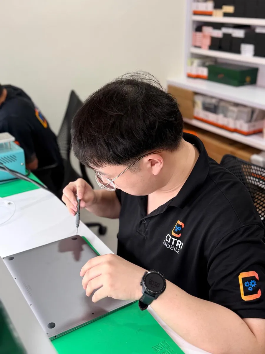 Citri Mobile technician opening a MacBook for battery and internal repair in Singapore