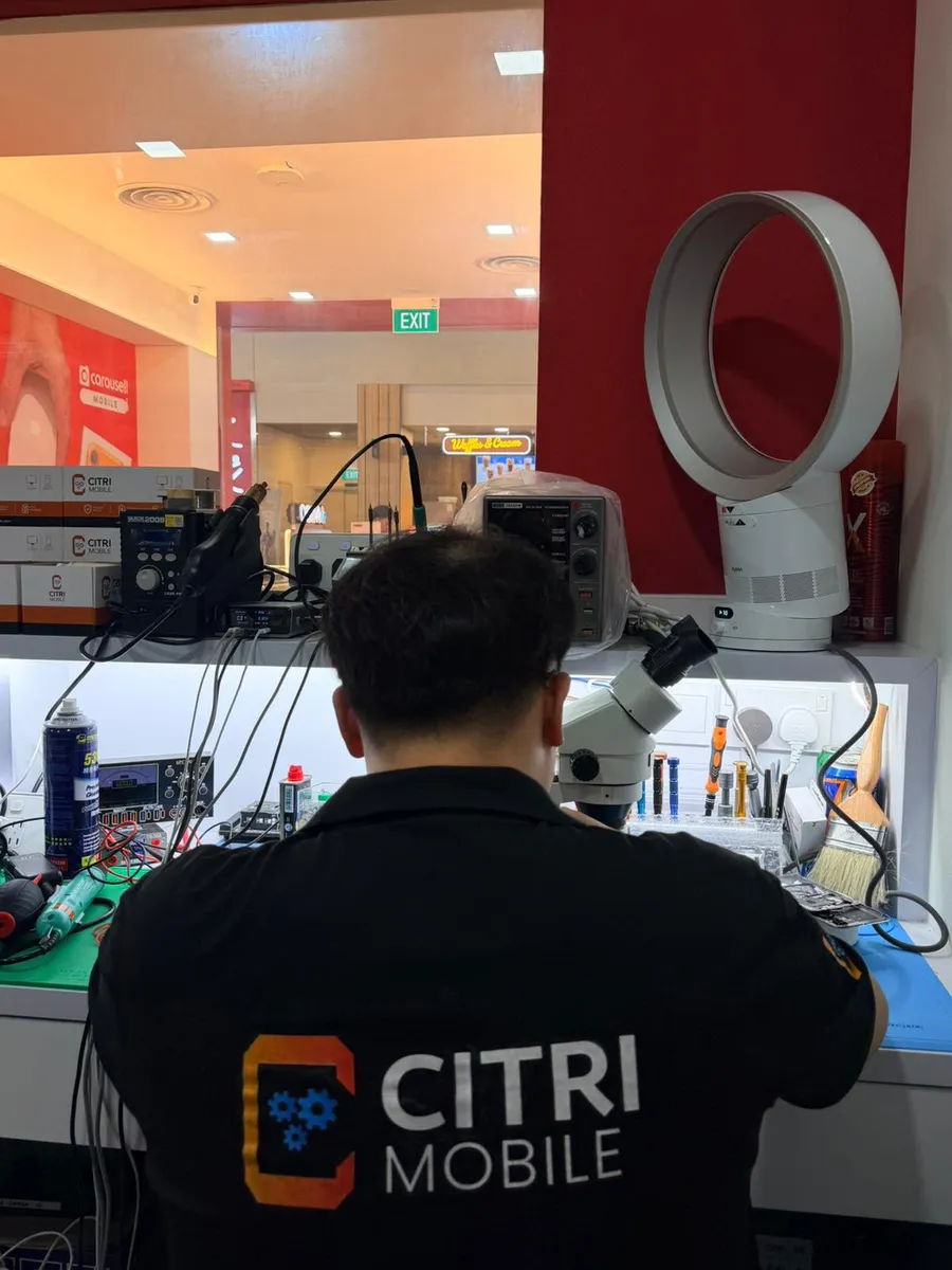 Citri Mobile technician doing microscope board-level iPhone repair at our Jurong Point counter